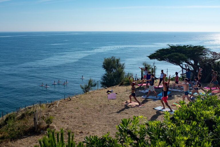 Camping Castels Les Criques de Porteils Gaeste entspannen beim Yoga im Schatten am Strand mit Blick auf das Mittlmeer 768x512