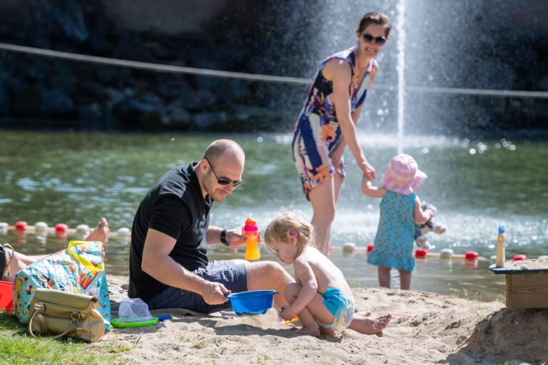 Camping De Wildhoeve Familie spielt im Sand am Strand beim Wasserspielplatz 768x512