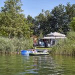 Camping TerSpegelt Boot fahrende Camper auf dem See am Campingplatz 150x150