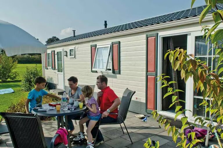 Campingpark Kerstgenshof Familie am Esstisch auf der Veranda vom Mobilheim auf dem Campingplatz 768x512