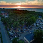 Campingpark Kuehlungsborn Luftaufnahme vom Campingplatz mit Strand an der Ostsee bei Sonnenuntergang 150x150