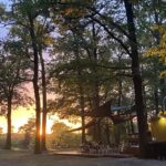 Campingplatz Am Kamernschen See Terrasse der Gastronomie umgeben von Baeumen bei Sonnenuntergang 88205c8f 53c6 4c29 8920 03783b235624 150x150