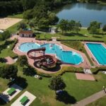 Campingplatz am Badesee Coswig Koetitz Campingplatz mit Pool Wasserrutsche Liegestuehlen und Sonnenschirmen 150x150