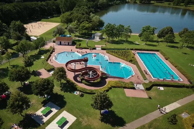 Campingplatz am Badesee Coswig Koetitz Campingplatz mit Pool Wasserrutsche Liegestuehlen und Sonnenschirmen 768x512