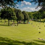 Campingplatz am Badesee Coswig Koetitz Die Gaeste liegen in der Sonne auf einem grossen gruenen Rasen 150x150