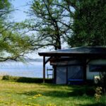 FKK Ferienidyll am Raetzsee Stellplatz im Schatten unter Baeumen mit Seeblick auf dem Campingplatz 150x150