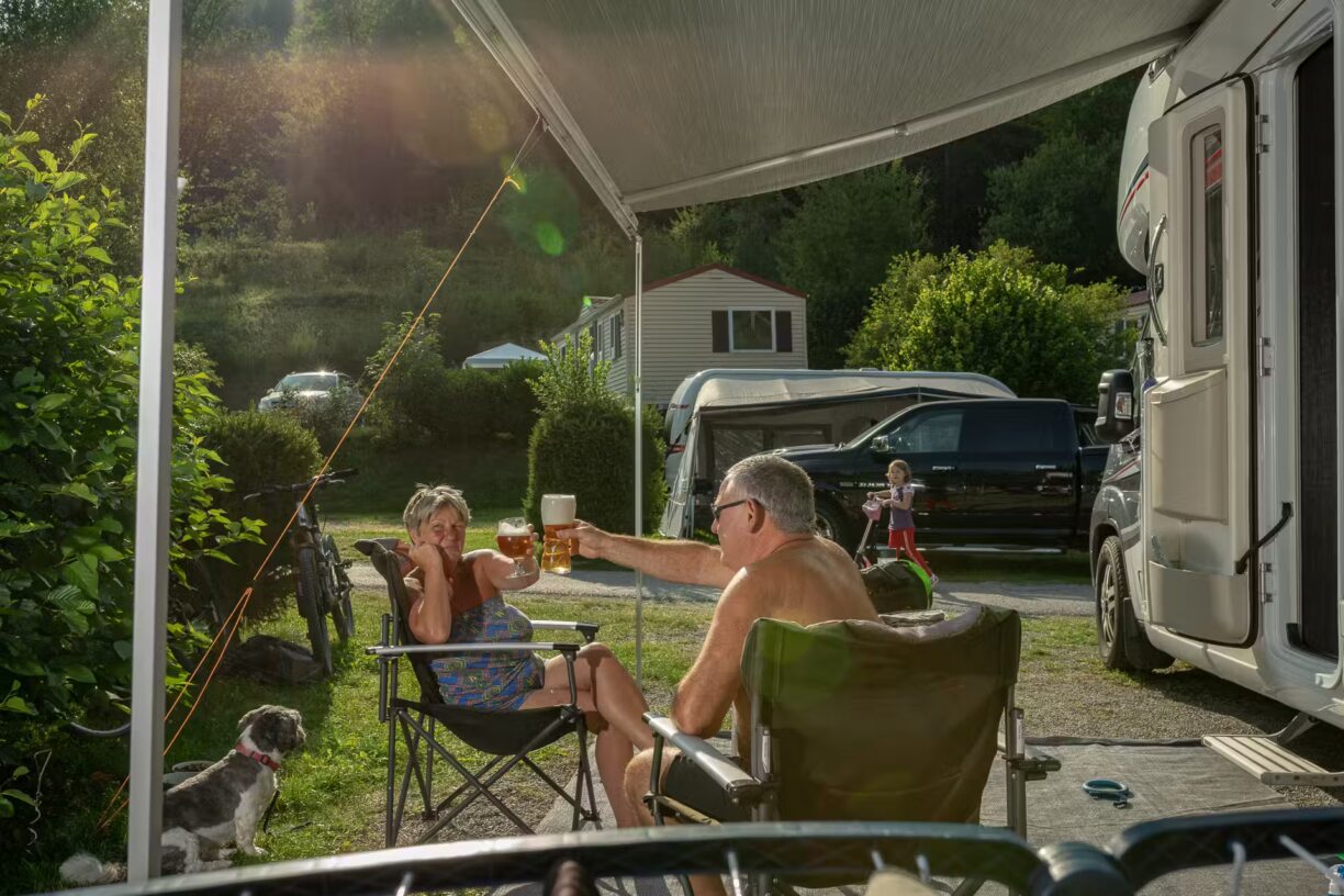 Family Resort Kleinenzhof Campingplatzgaeste stossen neben dem Wohnmobil an 1224x816