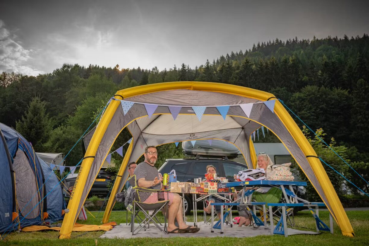 Family Resort Kleinenzhof Gaeste des Campingplatzes die am Tisch unter einem Zelt sitzen 1224x816