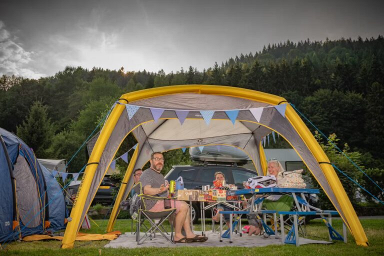 Family Resort Kleinenzhof Gaeste des Campingplatzes die am Tisch unter einem Zelt sitzen 768x512