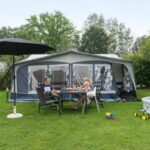 Kampeerdorp De Zandstuve Gaeaste vor ihrem Wohnwagen in der Sonne 150x150