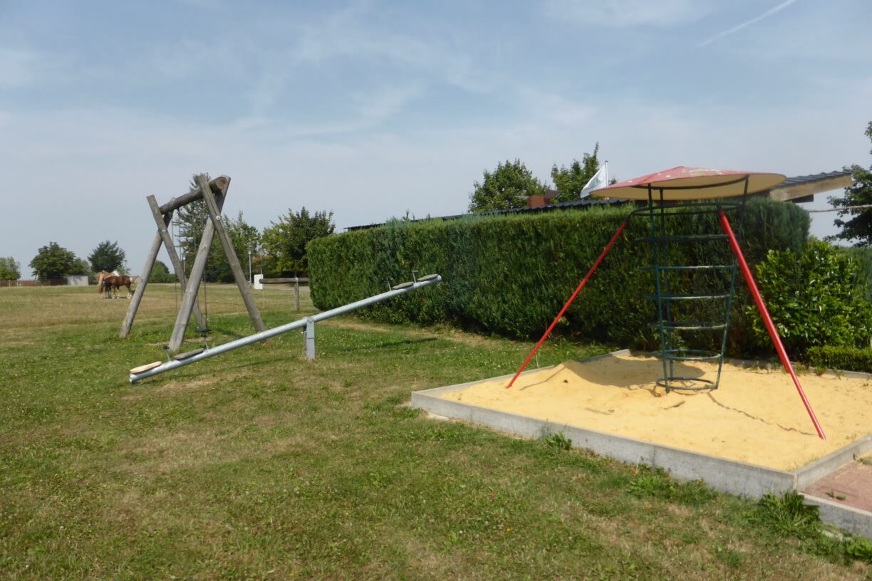 Komfort Campingplatz Panoramablick Kinderspielplatz mit Schaukel und Klettergeruest auf dem Campingplatz 1224x816