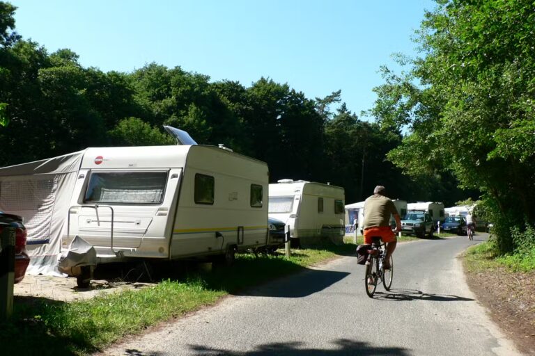 Naturcamping ckeritz Camper mit Fahrrad entlang der Wohnwagen und Wohnmobile auf dem Campingplatz 768x512