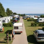 Ostseecamping Familie Heide Blick auf einen asphaltierten Campingplatzweg mit links und rechts davon liegenden parzellierten durch halbhohe Hecken getrennte Standplaetze 4b1ebbc1 456a 4b36 bbe3 a8e617dc453d 150x150