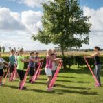 Rosenfelder Strand Ostsee Camping Gaeste beim Stretchingunterricht auf dem Campingplatzgelaende 150x150