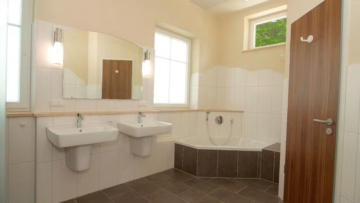 Strandcamping Waging Sanitaergebaeude mit Waschbecken Spiegel Toiletten und Badewanne 1224x689