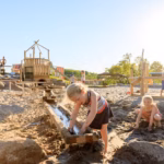 Vakantiepark Ackersate Familie spielt im Sand beim Sandspielplatz 150x150