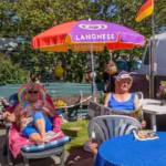 Camping Fluegger Strand Gaeste sonnen sich vor ihrem Wohnwagen  150x150