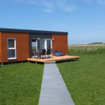 Campingplatz Flueggerteich Mobilheim vom Campingplatz mit Sitzsack und Esstisch auf der Veranda 150x150