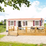 Ostsee Freizeitpark Booknis Blick auf Mobilheim mit Veranda auf dem sonnigen Gelaende vom Campingplatz 150x150