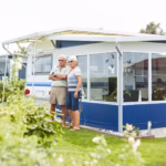 Ostsee Freizeitpark Booknis Gaeste vom Campingplatz vor dem Mobilheim mit Wohnwagenstellplatz 150x150