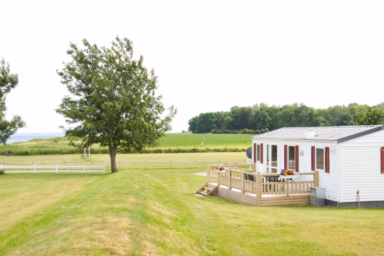 Ostsee Freizeitpark Booknis Mobilheim mit Veranda mit Blick auf die gruenen Felder auf dem Campingplatz 768x512