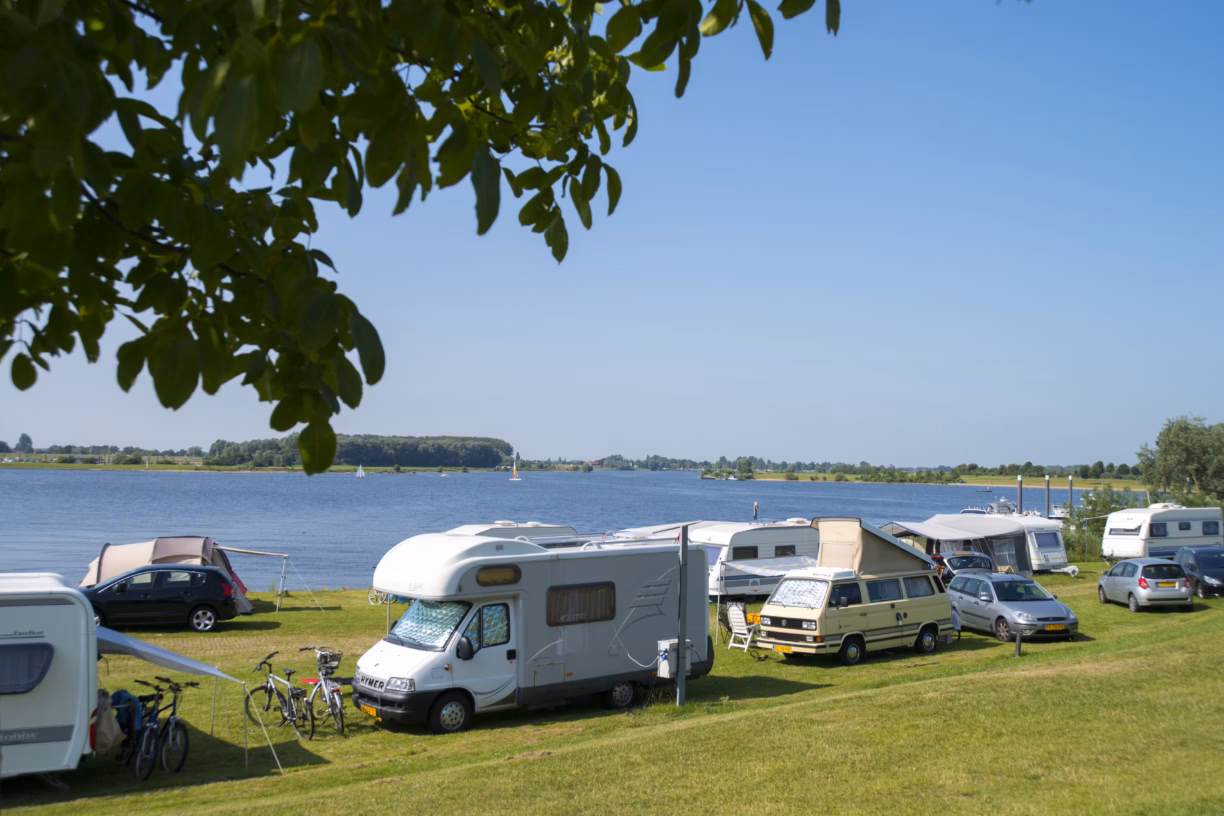 Vakantiepark Eiland van Maurik Wohnwagenstellplaetze im Gruenen auf dem Campingplatz mit Blick auf den See 1224x816